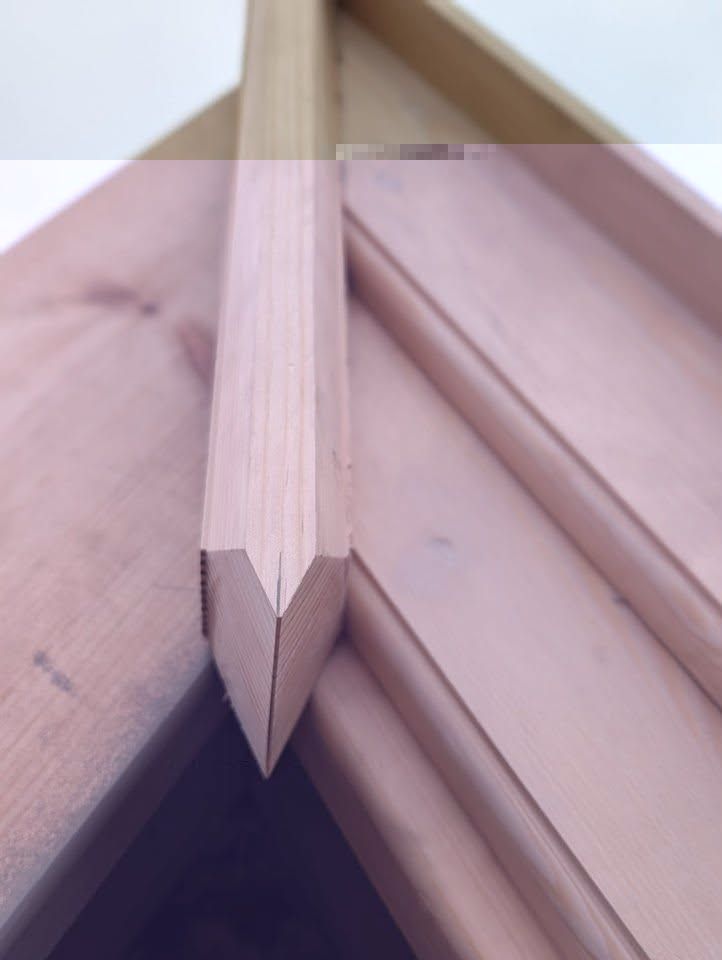 Close-up of a mitred timber ridge joint on a roofline